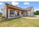 Inviting covered porch with wooden columns, ceiling fans, black rocking chairs, and a view of the well-manicured lawn at 1423 Hillcrest Rd, Bowdon, GA 30108