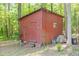 A red outbuilding is nestled amongst the trees and landscaping on the property at 2237 Walt Stephens Rd, Jonesboro, GA 30236