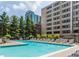 Outdoor pool with multiple lounge chairs, city views, and a nearby grassy park space at 878 Peachtree Ne St # 634, Atlanta, GA 30309