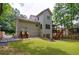 Back exterior featuring a wooden deck with stairs leading to the yard, surrounded by lush greenery at 2370 Burch Cir, Brookhaven, GA 30319