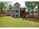 Expansive backyard featuring a large grassy area, wooden deck with stairs, and mature trees surrounding the perimeter at 2370 Burch Cir, Brookhaven, GA 30319