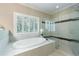 Bright bathroom featuring a soaking tub under a window and glass enclosed shower at 2370 Burch Cir, Brookhaven, GA 30319