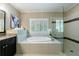 Bathroom features tile flooring, soaking tub with tile surround, frameless glass shower, and vanity at 2370 Burch Cir, Brookhaven, GA 30319