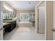 Bathroom with tile floor, double vanity, soaking tub, shower, and natural light from shuttered window at 2370 Burch Cir, Brookhaven, GA 30319
