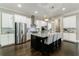 Well-lit kitchen with stainless steel refrigerator, granite countertops, and kitchen island with seating at 2370 Burch Cir, Brookhaven, GA 30319