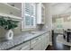 Bright kitchen area with granite countertops, white cabinets, and view into the dining room at 2370 Burch Cir, Brookhaven, GA 30319