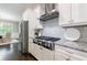 Modern kitchen features stainless steel appliances, granite countertops, and custom range hood at 2370 Burch Cir, Brookhaven, GA 30319