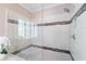 Bathroom glass shower enclosure with chrome shower head and decorative horizontal tile at 2370 Burch Cir, Brookhaven, GA 30319