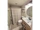 Bathroom featuring wood vanity with sink, shower with curtain, and round mirror at 5108 Hackett Ne St, Covington, GA 30014