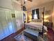 Bedroom featuring a four-poster bed, accent lamps, and ample storage with closet and drawers at 5108 Hackett Ne St, Covington, GA 30014
