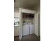 Well-organized laundry closet features a full-sized washer, dryer, and convenient storage shelf at 5108 Hackett Ne St, Covington, GA 30014