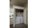 Cozy laundry closet with washer, dryer, and storage shelf for supplies at 5108 Hackett Ne St, Covington, GA 30014