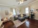 Cozy living room with a sectional, an ottoman, hardwood flooring, and natural light from multiple windows at 5108 Hackett Ne St, Covington, GA 30014