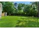 Expansive backyard with lush lawn, mature trees, and recreational features at 71 Headland Ct, Rockmart, GA 30153