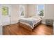 Small bedroom with hardwood floors, door to the outside, and two windows for natural light at 918 Washington Sw St, Atlanta, GA 30315