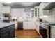 Modern kitchen featuring white cabinets, stainless steel appliances, granite counters, and hardwood floors at 918 Washington Sw St, Atlanta, GA 30315