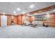 Basement featuring wood paneled walls, carpeted floors, and neutral furniture at 1325 Starboard Way, Cumming, GA 30041