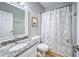 This bathroom includes a granite countertop and a shower with a butterfly curtain at 1325 Starboard Way, Cumming, GA 30041