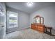 Bedroom with plush carpet, wooden dresser, and view from a window to outside seating area at 1325 Starboard Way, Cumming, GA 30041