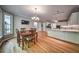 Open-concept dining room and kitchen with hardwood floors and modern chandelier lighting at 1325 Starboard Way, Cumming, GA 30041