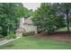 Exterior view of the home from the side with mature trees and landscaped lawn at 1325 Starboard Way, Cumming, GA 30041
