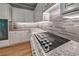Kitchen with smooth cooktop, stone backsplash, granite countertops, and stainless steel appliances at 1325 Starboard Way, Cumming, GA 30041