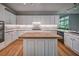 Kitchen island featuring a butcher block countertop, white cabinets, and stylish lighting at 1325 Starboard Way, Cumming, GA 30041