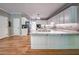 Open-concept kitchen with hardwood floors, island, and white cabinets with granite counters at 1325 Starboard Way, Cumming, GA 30041