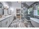 Stylish main bathroom features double vanities, marble countertops, soaking tub, glass shower, and marble floors at 1325 Starboard Way, Cumming, GA 30041