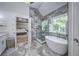 Bright main bathroom features soaking tub, marble floors and walls, and glass shower at 1325 Starboard Way, Cumming, GA 30041