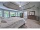 View of the main bedroom featuring tray ceiling, large windows, and ensuite bathroom at 1325 Starboard Way, Cumming, GA 30041