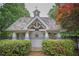 Charming pool house featuring a shingled roof, decorative details, and a secure black metal fence at 1325 Starboard Way, Cumming, GA 30041