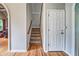 View of the carpeted staircase, with wood railings, located near the front door at 1325 Starboard Way, Cumming, GA 30041