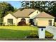 Charming single-story home with manicured lawn, lush landscaping, and an attached two-car garage at 2610 Stokesley Way, Snellville, GA 30078
