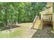 Backyard with a wooden deck, surrounded by lush greenery and trees at 4840 Chapel Hill Rd, Douglasville, GA 30135