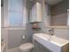 Modern bathroom featuring a sleek, rectangular sink and vanity, toilet, mirror, and a bright window for natural light at 733 Frederica Ne St # 17, Atlanta, GA 30306