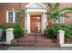 Charming brick building entrance featuring a striking red door with white columns, steps, and manicured landscaping at 733 Frederica Ne St # 17, Atlanta, GA 30306