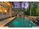 Backyard pool featuring stone waterfall, lush landscaping, and patio area for entertaining at 771 Phil Haven Ln, Kennesaw, GA 30152