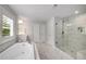 Bright bathroom featuring a soaking tub, marble floors, and glass-enclosed shower at 771 Phil Haven Ln, Kennesaw, GA 30152