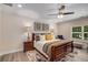 Comfortable bedroom featuring a ceiling fan, wood-trimmed bed frame, and natural light at 771 Phil Haven Ln, Kennesaw, GA 30152