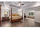 Spacious bedroom with tray ceiling, wooden floors, and comfortable seating area at 771 Phil Haven Ln, Kennesaw, GA 30152