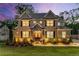 Beautifully illuminated exterior of a two-story brick home at dusk, enhancing its architectural details at 771 Phil Haven Ln, Kennesaw, GA 30152