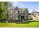 Charming two-story home with brick and stone accents, a manicured lawn, and lush landscaping at 771 Phil Haven Ln, Kennesaw, GA 30152
