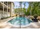 Backyard pool with waterfall feature surrounded by lush landscaping and patio area at 771 Phil Haven Ln, Kennesaw, GA 30152