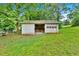 Detached garage with an open door and partially enclosed area, nestled in a green backyard at 14 Connie St, Cartersville, GA 30121