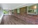 Inviting screened porch boasts wood-look floors and a brick accent wall, creating a cozy outdoor living space at 14 Connie St, Cartersville, GA 30121
