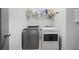 Organized laundry room with modern washer and dryer, shelf and a wire rack for storage at 1582 Cambridge Pl, Marietta, GA 30062