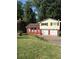 Split level home with red brick and siding, a two car garage, and a driveway at 801 Needle Rock Dr, Stone Mountain, GA 30083