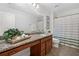 Bright bathroom featuring granite vanity, linen closet, and shower with striped curtain at 111 Millstone Way, Canton, GA 30115