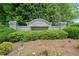 Elegant stone entrance sign for Millstone Creek community, surrounded by vibrant greenery and pine straw at 111 Millstone Way, Canton, GA 30115